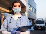 Healthcare worker standing outside a hospital
